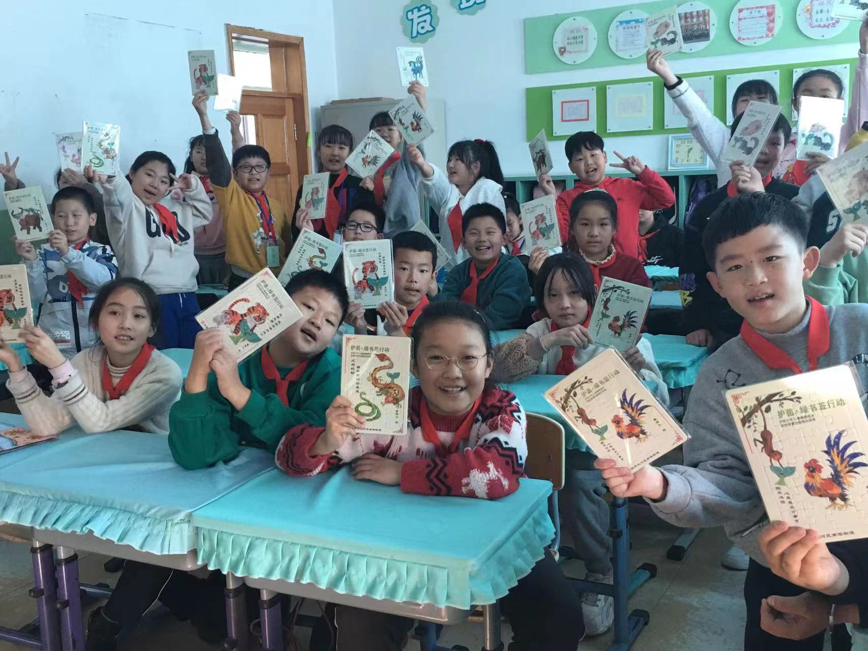 南塔街小学的学生手拿“护苗·十二生肖拼图”.jpg 南塔街小学的学生手拿“护苗·十二生肖拼图”.jpg